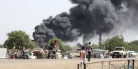 People drive as smoke rises from a fire at a market in the Upper Nile State town of Renk, South Sudan, 13 May 2023. (Photo: EPA-EFE / Amel Pain)