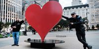 NEW YORK, NEW YORK - OCTOBER 25: Italian sculptor Sergio Furnari (R) and his partner Antonio Ingenito pose in front of the newly installed work Heroes Heart Monument in Grand Army Plaza on October 25, 2021 in New York City. The 3,000-pound sculpture pays tribute to healthcare workers and victims of Covid-19. The Italian sculptor Sergio Furnari created the work, which will be on display for an undisclosed period.  (Photo by Spencer Platt/Getty Images)