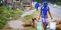 A settlement resident collects water from one of the only two public taps available. (Photo: Donna van der Watt)