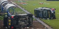 epa10218863 Damaged police vehicles lay on the pitch inside Kanjuruhan stadium in Malang, East Java, Indonesia, 02 October 2022. At least 127 people including police officers were killed mostly in stampedes after a clash between fans of two Indonesian soccer teams, according to the police.  EPA-EFE/SANDI SADEWA