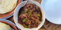 Goat stew is cooked with love, purple onions, green peppers and mustard seeds. (Photo: Bridget Hilton-Barber)<br>