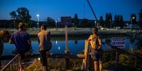 Onlookers and locals look on a team of rescuers managed an operation to move a lost Beluga whale locked in the Seine river in Saint Pierre la Garenne, Normandy Region, France, 09 August 2022. EPA-EFE/Christophe Petit Tesson