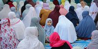 A girl looks straight as her mother performs Eid Al-Fitr prayer out site the Al-Bukhari Foundation Mosque (Masjid Al-Bukhary) on 22 April 2023 in Kuala Lumpur, Malaysia. (Photo: Annice Lyn / Getty Images)