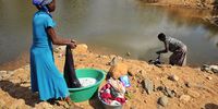 Vhusiwana Matsindi and Sarah Mukwevho wash their clothes at the Ritavi River. They are both unemployed and can't afford to buy water — and the one drum delivered to them once in a while is not enough for household chores. (Photo: Lucas Ledwaba / Mukurukuru Media)