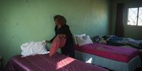 A caregiver makes a bed, one of her daily duties. (Photo: Shiraaz Mohamed)