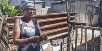 A neighbour, Maggie Basse, speaks to the press outside the  locked up shack in Site B  Q section in Khayelitsha, Cape Town, where Zandile Christmas Mafe lives on 04 January 2022. (Photo: Brenton Geach)