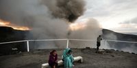 TANNA, VANUATU - DECEMBER 02: A tour guide (C) keeps warm as tourists visit Mount Yasur volcano, the main tourist attraction on the island, on December 02, 2019 in Tanna, Vanuatu. Tanna was hard hit by Cyclone Pam in 2015, a category 5 storm, which impacted tourism, a mainstay of Vanuatu's economy. Satellite data show sea level has risen about 6mm per year around Vanuatu since 1993, a rate nearly twice the global average, while temperatures have been increasing since 1950. 25 percent of Vanuatu’s 276,000 citizens lost their homes in 2015 when Cyclone Pam, a category 5 storm, devastated the South Pacific archipelago of 83 islands while wiping out two-thirds of its GDP. Scientists have forecast that the strength of South Pacific cyclones will increase because of global warming. Vanuatu’s government is considering suing the world’s major pollution emitters in a radical effort to confront global warming challenges and curb global emissions, to which it is a very small contributor. (Photo by Mario Tama/Getty Images)