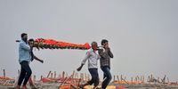 SHRINGVERPUR, INDIA - MAY 20: (EDITOR'S NOTE: Image depicts death.) Relatives carry a body for cremation past the graves of people, some of which are believed to be Covid-19 victims, that are partially exposed in shallow sand graves after rains washed away the top layer of sand at a cremation ground on the banks of the Ganges River on May 20, 2021 in Shringverpur, northwest of Allahabad, Uttar Pradesh, India. Gravediggers at the site said that there was a threefold increase in the number of bodies arriving for burials and cremations since April. Teams of police and local officials have been patrolling several areas along the river in Uttar Pradesh and Bihar to discourage burials on its banks, and to warn people of possible infection risks, local media reported. India's prolonged and debilitating wave of Covid-19 infections has reached deep into rural India, where the true extent of devastation may never be known because of a lack of widespread testing or reliable data. (Photo by Ritesh Shukla/Getty Images)