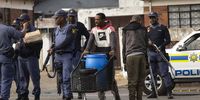 Members from the Westbury area walk through a police checkpoint with a shopping trolley carrying water containers during a protest demanding that their water supply be restored, in Johannesburg, South Africa, 10 September 2025. Following two weeks without water, Westbury residents have taken to the streets to try to get their water supply switched on after a number of issues have plagued the city's water supply. Significant water infrastructure issues in the city have resulted from years of mismanagement by the ruling ANC (African National Congress) and have led to the situation in this area and others in the country's biggest city.  EPA/Kim Ludbrook