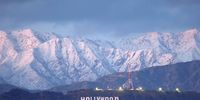 LOS ANGELES, CALIFORNIA - MARCH 01: The Hollywood sign stands in front of snow-covered mountains after another winter storm hit Southern California on March 01, 2023 in Los Angeles, California. The final in a series of winter storms in the Los Angeles region brought snow levels to as low as 1,000 feet in some places while further boosting the snowpack. California’s snowpack level stands at 189 percent of the average for March 1, according to the California Department of Water Resources. California Governor Gavin Newsom has declared a state of emergency due to winter storms for 13 counties including Los Angeles County. (Photo by Mario Tama/Getty Images)