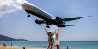 Tourists pose for photos with inbound planes on Mai Khao Beach on March 24, 2024 in Phuket, Thailand. The upcoming season of "The White Lotus" is anticipated to have a massive impact on tourism in Thailand, with travel forecasters predicting a surge in visitors to destinations like Koh Samui, Phuket, and Bangkok. The allure of experiencing the real-life locations featured in the series is expected to fuel a travel trend, drawing attention to Thailand as a top-tier bucket list destination for global travellers. (Photo by Lauren DeCicca/Getty Images)