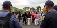 South African Police Service officers monitor the service delivery protest in Voortrekker Road, Kensington, on Monday 15 September 2025. (Photo: Tamsin Metelerkamp)