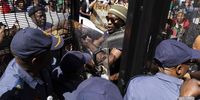 A protester clashes with members of the South African Police Force (SAPS) as activists from various civil organizations and supporters gather to protest in solidarity with Palestinians, at the head offices of the Department of Trade and Industry in Pretoria, South Africa, 21 August 2025. The protesters claim that the export of South African coal to Israel powers Israel's coal-powered power stations and this constitutes support of Israel's attacks on the Palestinian people.  EPA/Kim Ludbrook