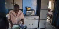 Keamogetse Mogotsi washing dishes in her kitchen. Mogotsi does not have a tap or a borehole in her yard and rely's on her nephew to collect water for her. (Photo: Shiraaz Mohamed)
