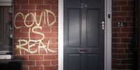 LEEDS, UNITED KINGDOM - JUNE 08: Graffiti declaring 'COVID IS REAL' is spray painted on the wall of a home in the Hyde Park area on June 08, 2021 in Leeds, United Kingdom. (Photo by Christopher Furlong/Getty Images)