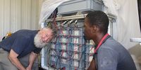 Chris Buckley and community liaison officer Nelson Khumalo inspect the business end of a ‘uricity’ prototype power plant, which was used to convert urine into Pee Power electricity. Image: Tony Carnie