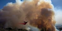 GOLETA, CA - OCTOBER 13: A firefighting jet drops fire retardant as the Alisal Fire burns on October 13, 2021 near Goleta, California. Pushed by high winds, the Alisal Fire grew to 6,000 acres overnight, shutting down the much-traveled 101 Freeway along the Pacific Coast. (Photo by David McNew/Getty Images)