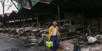 A worker passes by burnt-out vehicles inside the office of the Department of Development which were set on fire by protesters during Monday's anti-corruption protests, on September 11, 2025 in Kathmandu, Nepal. Nepal has been rocked by massive youth-led protests in September 2025, triggered by anger over government corruption, nepotism, and the banning of popular social media platforms. (Photo by Ritesh Shukla/Getty Images)
