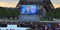 France’s centrist incumbent President Emmanuel Macron appears on TV over a banner declaring ‘Nous tous’ (all of us) after he beat  far-right rival Marine Le Pen for a second five-year term. (Photo: Aurelien Meunier / Getty Images)