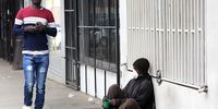 epa08328521 A man (L) walks past a blind man wearing a face mask begs for alms on a street pavement in Harare, Zimbabwe, 28 March 2020. Zimbabwean President Emmerson Mnangagwa has announced a 21 day lockdown starting 30 March 2020 in an effort to curb the spread of the Covid-19 coronavirus pandemic that has so far claimed one life in the country.(Photo:  EPA-EFE/AARON UFUMELI)