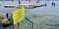 Visitors, including children, swimming in Kalk Bay’s Dalebrook tidal pool in 2024 despite a warning sign posted by the City.  2023. (Photo: Steve Kretzmann)