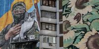 Artist Olena Noyna (L) works on a mural depicting a Ukrainian serviceman holding a cat, on a building in Kyiv, Ukraine, 03 October 2023, amid the Russian invasion.  EPA-EFE/Oleg Petrasyuk