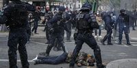 Riot police surround a man lying on the pavement during clashes at a rally against the government's pension reform in Paris, France, 28 March 2023. France faces an ongoing national strike against the government's pensions reform after tthe French prime minister announced on 16 March 2023 the use of Article 49 paragraph 3 (49.3) of the French Constitution to have the text on the controversial pension reform law - raising retirement age from 62 to 64 - be definitively adopted without a vote.  EPA-EFE/CHRISTOPHE PETIT TESSON