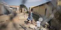 A woman fills her bucket from a trickling tap. The local municipality reported  the theft of a 70mm pipe and said they have replaced it with a smaller pipe thus giving off a lower pressure. (Photo: Shiraaz Mohamed)