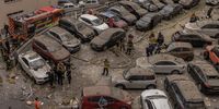 KYIV, UKRAINE - JUNE 24: Police, emergency personnel and residents gather at a car park with damaged cars next to the heavily damaged apartment building that was hit by a downed Russian missile on June 24, 2023 in Kyiv, Ukraine. At least three people died as Russian forces fired more than 20 missiles at the Ukrainian capital before dawn on Saturday. (Photo by Roman Pilipey/Getty Images)