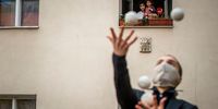 Residents of an apartment building observe from a window a juggler, member of the artistic group Cirk La Putyka, while performing to entertain residents as the spread of the coronavirus disease (COVID-19) continues on April 14, 2020 in Prague, Czech Republic. The Czech government has imposed a lockdown in an attempt to slow down the spread of the pandemic COVID-19 disease. The country has reported more than 6,000 cases of COVID-19. (Photo by Gabriel Kuchta/Getty Images)
