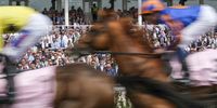 CHESTER, ENGLAND - MAY 10: Racegoers look on as runners pass during The Boodles Darley 'Confined' Maiden Stakes at Chester Racecourse on May 10, 2024 in Chester, England. (Photo by Alan Crowhurst/Getty Images)