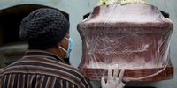 LIMA, PERU - JUNE 01: A man touches the coffin of his relative Marco Antonio Carillo, 48, who died of COVID-19 according to his family during his burial at the "Martires 19 de Julio" cemetery on June 1, 2021 in Lima, Peru. After a government review carried by experts, Peru more than doubled the number of deaths by coronavirus. With now 180,764 deceases and a population of 33 million, it turns into the country with the worst death rate per capita. Numbers have been underestimated, in part, due to lack of testing. (Photo by Angela Ponce/Getty Images)