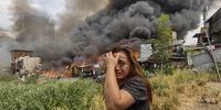 A resident reacts during a fire in Damayang Lagi district in Quezon City, Metro Manila, Philippines, 19 March 2024. At least one person was injured as the fire reached Task Force Alpha level, according to the Bureau of Fire Protection. Authorities are investigating the cause of the blaze which spread through a still undetermined number of houses made of light materials.  EPA-EFE/ROLEX DELA PENA