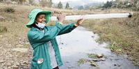 Enviro Champ Sanelisiwe Nzimande takes a turbidity reading using a clarity tube. (Photo: Khaya Ngwenya)