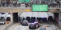 Police officers take cover as activists shower rocks and debris on to their vehicles during protests in  LA on 8 June. (Photo: Allison Dinner / EPA-EFE)