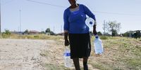 Constance Ngobeni, a resident of Hammanskraal, with clean drinking water she had to buy in May 2023. (Photo: Felix Dlangamandla)