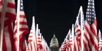 The U.S. Capitol near the "Field of Flags" on the grounds of the National Mall at night ahead of the 59th Inaugural Ceremonies in Washington, D.C., U.S., on Monday, Jan. 18, 2021. After planning a scaled-back inauguration celebration for President-elect Joe Biden due to the Coronavirus pandemic, the National Mall has been closed down entirely to all spectators due to security concerns following the insurrection of the U.S. Capitol. Photographer: Stefani Reynolds/Bloomberg via Getty Images