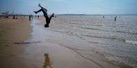 LIVERPOOL - UNITED KINGDOM JUNE 25: A youth practices his gymnastic moves as people enjoy the warm weather on Crosby Beach on June 25, 2020 in Liverpool, United Kingdom. The UK is experiencing a summer heatwave, with temperatures in many parts of the country expected to rise above 30C and weather warnings in place for thunderstorms at the end of the week. (Photo by Christopher Furlong/Getty Images)