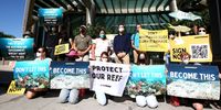 Activists stand outside the Queensland government office building in Brisbane in March 2022 during a protest to highlight the risk that climate change poses to the Great Barrier Reef. (Photo: EPA-EFE / Jono Searle) 