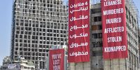 epa09395584 Giant banners are placed on a building that was damaged during the massive blast on 04 August 2020 in Beirut port in Beirut, Lebanon, 04 August 2021. Lebanon marks a year since an explosion ravaged the Beirut port area, killing at least 200 people and injuring thousands more in the Beirut blast that devastated the port area on 04 August 2020.  EPA-EFE/WAEL HAMZEH