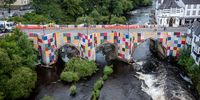 LLANGOLLEN, DENBIGHSHIRE - JULY 08: Patchwork panels entitled  ‘Bridges, Not Walls’ by artist Luke Jerram cover Llangollen Bridge on July 08, 2021 in Llangollen, Denbighshire. The Llangollen International Musical Eisteddfod, an annual festival starting this month, commissioned artist Luke Jerram to create the patchwork, inviting local residents and festival fans to submit 1m x 1m fabric squares reflecting the crafts and culture of Wales. (Photo by Christopher Furlong/Getty Images)