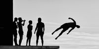 Photographed at Kolovare beach in Zadar, Croatia, this black-and-white image shows the silhouettes of men jumping from the diving platform into the sea. (Photo: Marko Buntić, Croatia, Winner, Regional Awards, Sony World Photography Awards 2025)