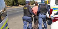 JOHANNESBURG, SOUTH AFRICA - JUNE 04:A man detained at the shooting scene in Riverlea after a shoot out between illegal miners and police on June 04, 2025 in Johannesburg, South Africa. It is reported that the area has been under siege from zama zamas with authorities battling to root out the problem for years. (Photo by Gallo Images/Luba Lesolle)