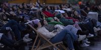 The audience listens as artist Alain Roche plays a piano concert while hanging from a crane, in Munich, Germany, 19 March 2024. Audience of the project 'When The Sun Stands Still' listened to the piano played, mixed with the sound of awakening nature. Over 40 highly sensitive microphones were placed in nature throughout Bavaria and Switzerland. The Audience listened to the performance through headphones facing east as the night sky turned to light. The duration and start time of the concerts are different every day: they are based on the Earth's elliptical orbit around the sun. People can experince the concerts until 20 June 2024.  EPA-EFE/ANNA SZILAGYI