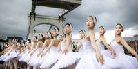 Some of the 48 dancers from Shanghai Ballet perform on the bridge Magere Brug on the occasion of 'The Greatest Swan Lake in the World' show in Amsterdam, The Netherlands, 29 August 2023. At the start of the new theater season, the Royal Theatre Carre presents 'The Greatest Swan Lake in the World' from 30 August to 17 September 2023.  EPA-EFE/RAMON VAN FLYMEN