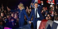 PARIS, FRANCE - APRIL 24: France's centrist incumbent president Emmanuel Macron and his wife Brigitte Macron acknowledge voters in front of the Eiffel Tower after after giving a speech after beating his far-right rival Marine Le Pen for a second five-year term as president with 58,8% votes on April 24, 2022 in Paris, France. Emmanuel Macron and Marine Le Pen both qualified on Sunday April 10th for France's 2022 presidential election second round held today, on April 24. This is the second consecutive time the two candidates face-off in the final round of elections. (Photo by Aurelien Meunier/Getty Images)