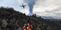 epa09512685 A handout photo made available by the Spanish Military Emergencies Unit (UME) shows an UME member operating a drone to study the evolution of the Cumbre Vieja volcano's ongoing eruption in La Palma, Canary Islands, Spain, 08 October 2021.  EPA-EFE/LUISMI ORTIZ/UME HANDOUT -- MANDATORY CREDIT -- HANDOUT EDITORIAL USE ONLY/NO SALES