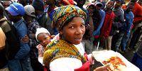 Mozambican and Zimbabwean refugees from xenophobic violence receive food aid from the South African Red Cross Society at a refugee camp in Johannesburg, South Africa, 27 May 2008. (Photo: EPA / Jon Hrusa)