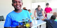 A young boy  with a robot vehicle he built  in a school robotics class.Photo: iStock