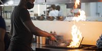 Darth Kitchens griller Passmore Matonga prepares an order of burgers on Wednesday 4 November 2020 in Cape Town, South Africa. (Photo: Leila Dougan)